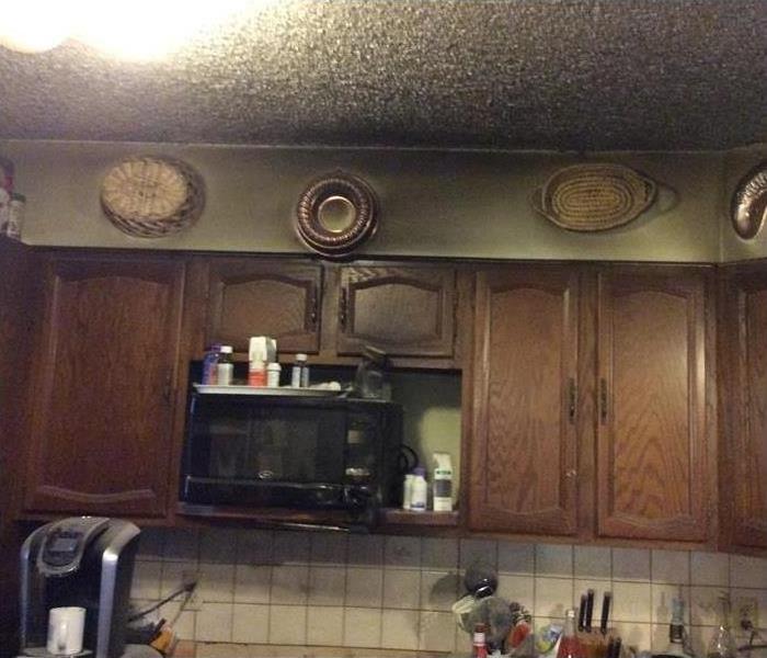 slightly charred wall cabinets and ceiling from a kitchen fire