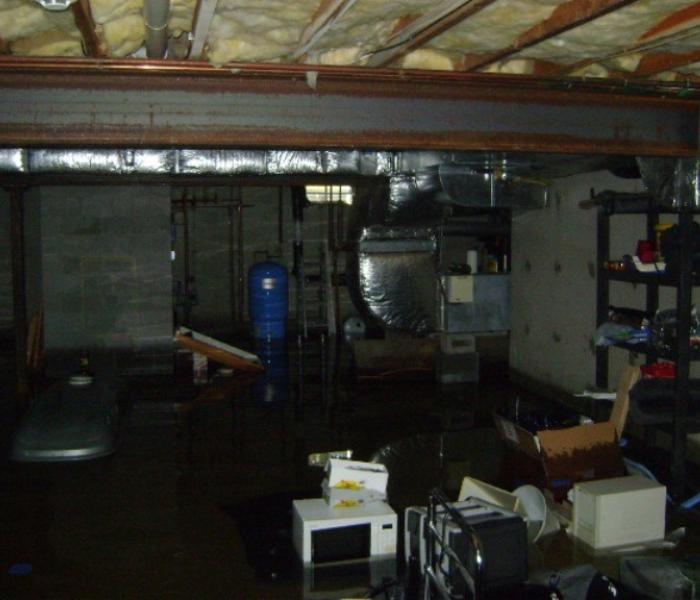 A flooded basement with deep water submerging furniture and household items