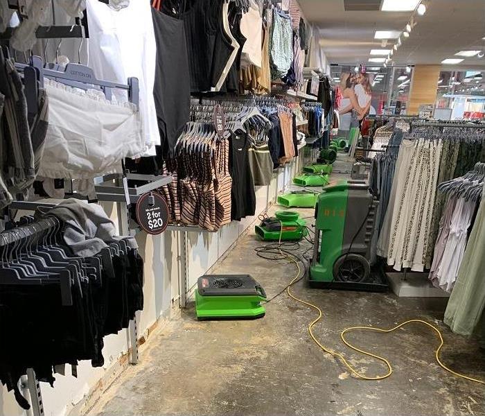 water damaged clothing store; SERVPRO restoration equipment being used on floor to dry area