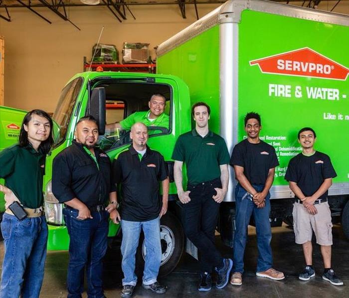 A group of SERVPRO workers standing in front of a truck. 