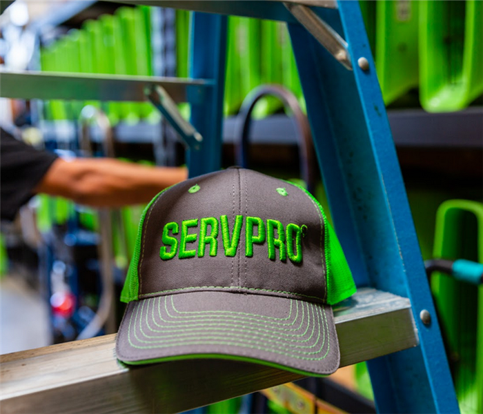 a gray and green SERVPRO hat sitting on a ladder in a SERVPRO facility