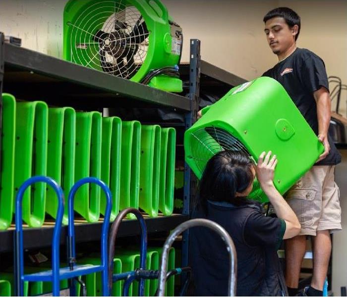SERVPRO technicians stacking restoration equipment in storage facility