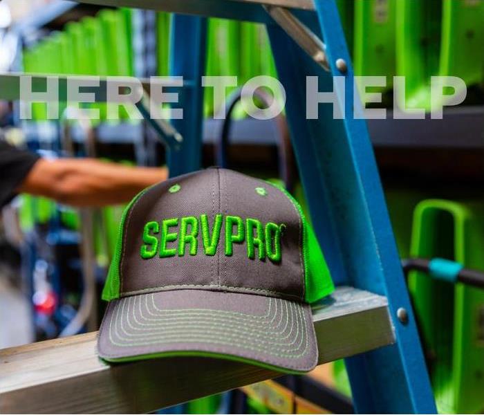 SERVPRO hat on a ladder in front of water damage equipment